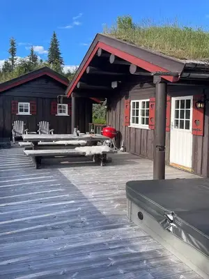 a building with a deck with a grass roof at Log Cabin With Panoramic Views At Skeikampen in Svingvoll