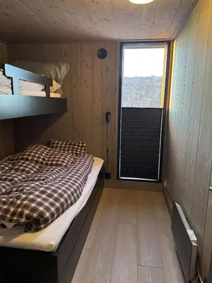 a small room with a bed and a window at Beautiful Ski-in Ski-out Cabin at the top of the mountain in Hafjell in Hafjell