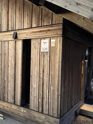 a building with an open door with a sign on it at Beautiful Ski-in Ski-out Cabin at the top of the mountain in Hafjell in Hafjell