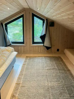a small room with a bed and two windows at Cabin At Groholsfjellet For Active Days in Veggli
