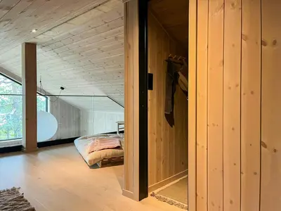 a bedroom with a bed in a room with wooden walls at Cabin At Groholsfjellet For Active Days in Veggli