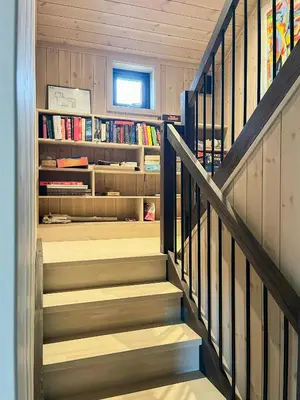 a staircase in a house with bookshelves at Cabin At Groholsfjellet For Active Days in Veggli