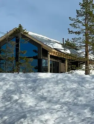 a house in the snow with a pile of snow at Cabin At Groholsfjellet For Active Days in Veggli