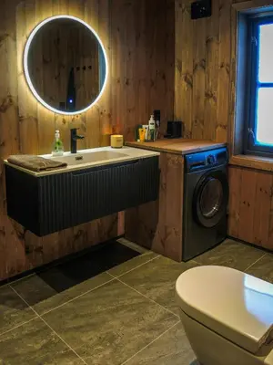 a bathroom with a sink and a washing machine at Cabin With Sauna And Views Over Hallingdal in Flå