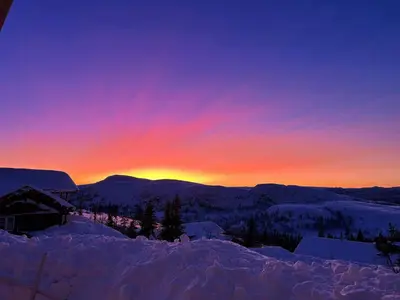 a sunset in the mountains with snow on the ground at Cabin With Sauna And Views Over Hallingdal in Flå