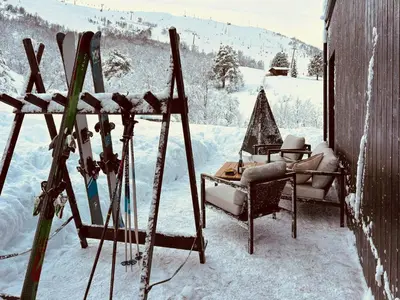 a room with skis and chairs in the snow at Cabin With Ski-Inski-Out At Stranda Ski Resort in Stranda