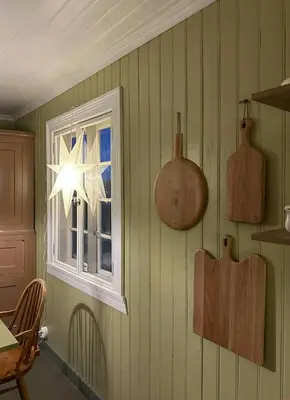 a kitchen with green walls and a window and wooden utensils at Charming Farmhouse From 1919 Near Kristiansund in Kristiansund