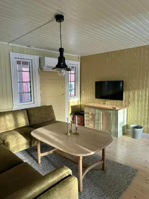 a living room with a table and a couch at Charming Farmhouse From 1919 Near Kristiansund in Kristiansund