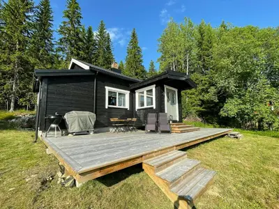 a black tiny house with a wooden deck at Renovated Cabin On The West Side Of Trysil in Trysil