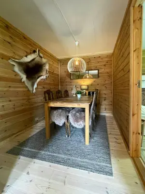 a dining room with a table in a wooden room at Renovated Cabin On The West Side Of Trysil in Trysil