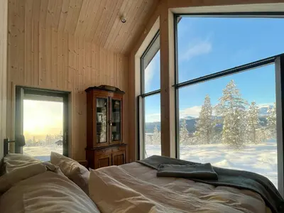 a bedroom with a bed in front of a large window at Eco-Friendly Cabin With Panoramic Views In Savalen in Tynset