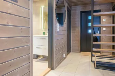 a bathroom with wooden walls and a walk in closet at Modern Cabin With Ski-Inski-Out At Hafjell in Øyer