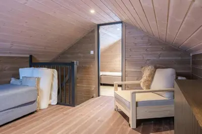 a room with a bed and a chair in a attic at Modern Cabin With Ski-Inski-Out At Hafjell in Øyer
