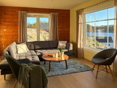 a living room with a couch and a table at Seafront House From 1952 With Views In Veivåg in Bekkjarvik