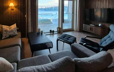 a living room with two couches and a table and a television at Flat With Lake View In Sjusjøen in Sjusjøen