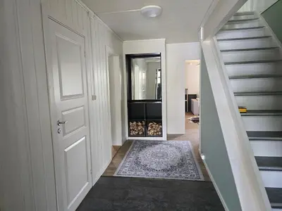 a hallway with a white door and a staircase at Fjellro appartment in Os