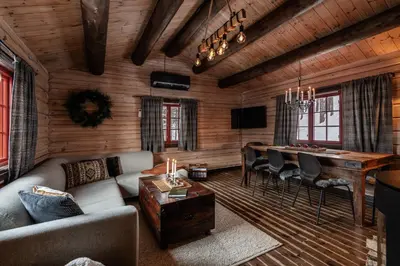 a living room with a couch and a dining room table at Charming cabin by Hallingskarvet ski center in Hol