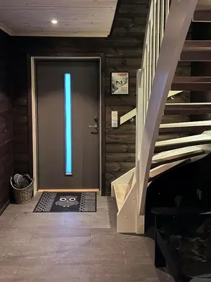 a door with a blue light on it next to a staircase at Moderne Og Koselig Hytte På Hardangervidda in Garden
