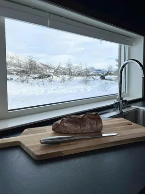a steak on a cutting board in front of a window at Moderne Og Koselig Hytte På Hardangervidda in Garden