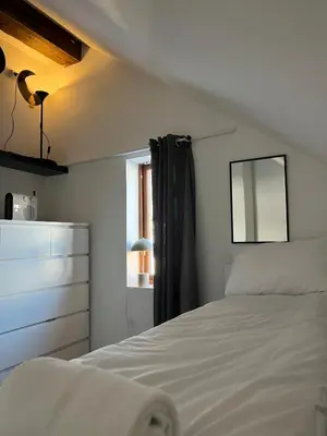 a bedroom with a white bed and a window at Prime Location - Cozy and Big House in Vossevangen
