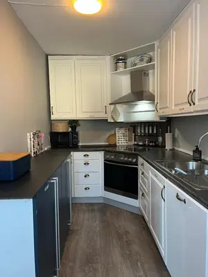 a kitchen with white cabinets and black counter tops at Prime Location - Cozy and Big House in Vossevangen