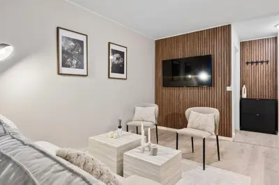 a living room with a couch and chairs and a tv at Central stay apartment - Rosenberg in Bergen
