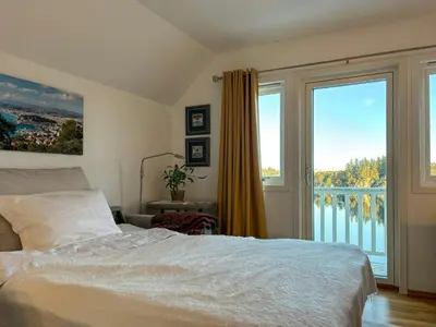a bedroom with a bed and a large window at House With 90 Metres Private Beach On Bømlo in Ervik