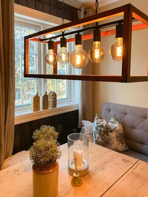 a chandelier with lights over a wooden table at Family Cabin With Hot Tub At Skeikampen in Svingvoll