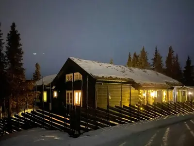 a house covered in snow at night with lights at Family Cabin With Hot Tub At Skeikampen in Svingvoll