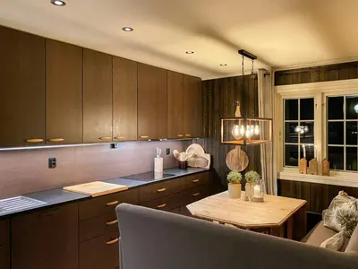 a kitchen with wooden cabinets and a wooden table at Family Cabin With Hot Tub At Skeikampen in Svingvoll