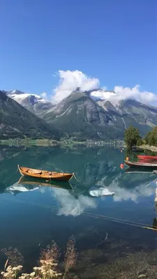 two boats on a lake with mountains in the background at Olastova, et koselig lite hus i nær Stryn sentrum in Stryn
