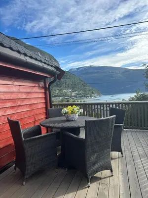 a patio with a table and chairs on a deck at Olastova, et koselig lite hus i nær Stryn sentrum in Stryn