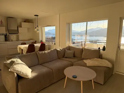 a living room with a couch and a table at Modern and central apartment with a view in Ålesund