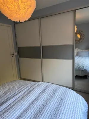 a bedroom with a bed and a large mirror at Modern and central apartment with a view in Ålesund
