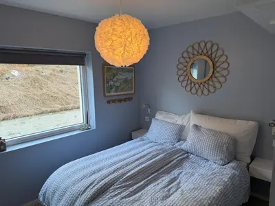 a bedroom with a bed and a window and a mirror at Modern and central apartment with a view in Ålesund