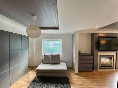 a living room with a couch and a television at Trolltunga Fjordview House, Odda in Odda