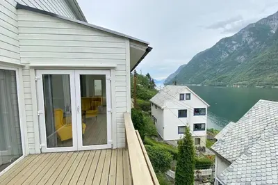 a house with a balcony with a view of a lake at Trolltunga Fjordview House, Odda in Odda
