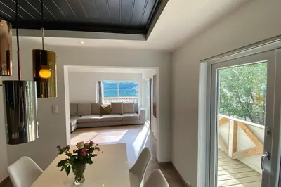 a living room with a table and a couch at Trolltunga Fjordview House, Odda in Odda