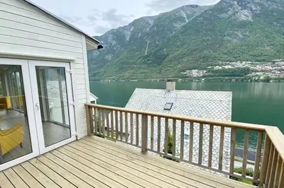 a balcony with a view of a lake and mountains at Trolltunga Fjordview House, Odda in Odda
