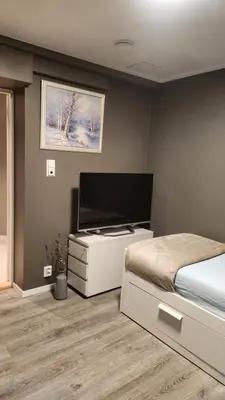 a bedroom with a bed and a flat screen tv at Fjordclaw SNM- Cozy & Premium Feel in Bergen