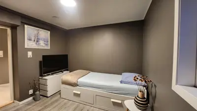 a bedroom with a bed and a flat screen tv at Fjordclaw SNM- Cozy & Premium Feel in Bergen