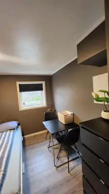 a room with a table and chairs and a bed at Fjordclaw SNM- Cozy & Premium Feel in Bergen