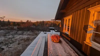 a bench sitting on the side of a building at Fjellhytte med boblebad og utsikt på Blefjell in Flesberg
