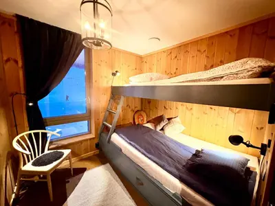 a bedroom with two bunk beds and a chair at Elegant 2 bedroom ski in, ski out apartment next to Fyri Resort in Hemsedal in Hemsedal