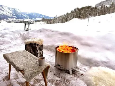 a fire pit and a chair in the snow at Elegant 2 bedroom ski in, ski out apartment next to Fyri Resort in Hemsedal in Hemsedal
