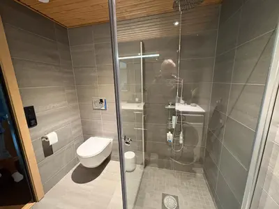 a man taking a picture of a shower in a bathroom at Elegant 2 bedroom ski in, ski out apartment next to Fyri Resort in Hemsedal in Hemsedal