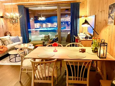 a dining room with a table and chairs and a living room at Elegant 2 bedroom ski in, ski out apartment next to Fyri Resort in Hemsedal in Hemsedal