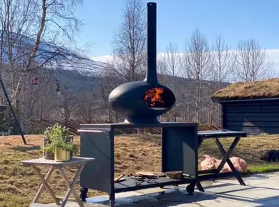 a pizza oven with a fire inside of it at Timber Cabin With Hot Tub In Gjevilvassdalen in Oppdal