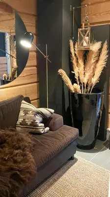 a living room with a couch and a vase with feathers at Timber Cabin With Hot Tub In Gjevilvassdalen in Oppdal