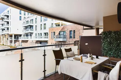 a table on a balcony with a view of a building at City apartment with balcony and 3 bedrooms! in Bergen